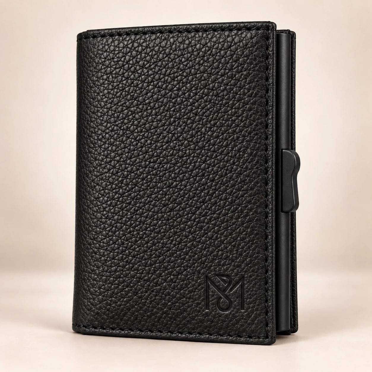 A close view of a black MONOBRIHI wallet with its embossed monogram