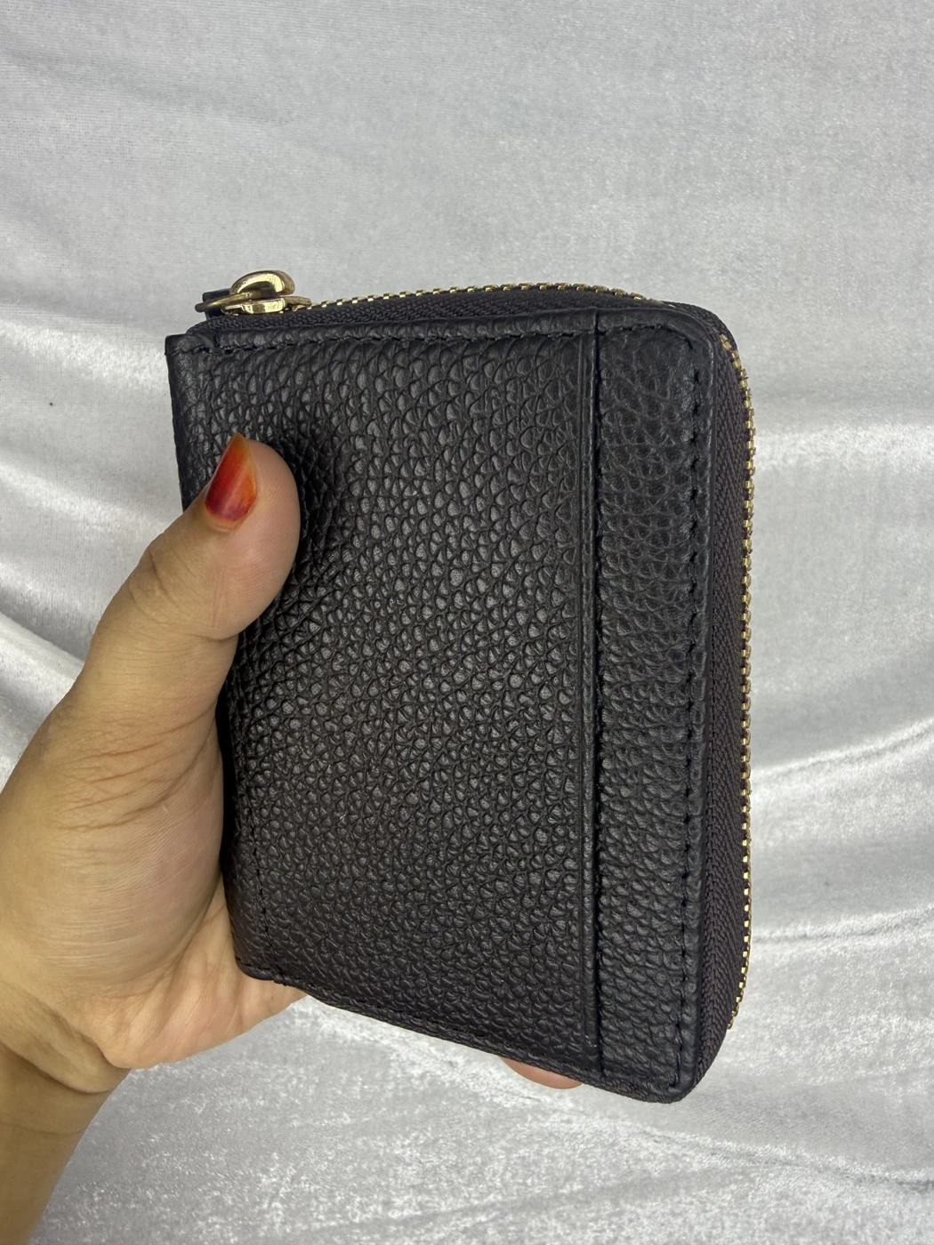 A black MONOBRIHI wallet pictured with a zip closure